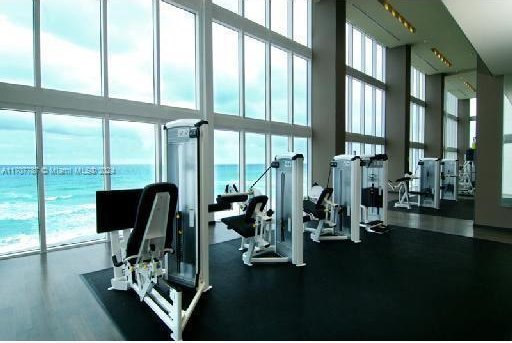 gym with expansive windows and a water view