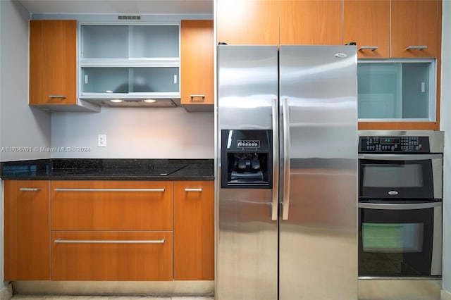 400 Alton Rd Unit 2309, Miami Beach, FL 33139 - kitchen featuring stainless steel appliances, dark stone counters, brown cabinetry, and open shelves