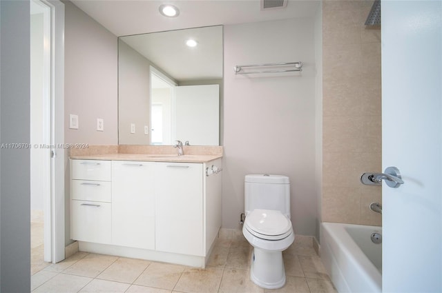 full bathroom with tile patterned floors, tiled shower / bath, vanity, and toilet