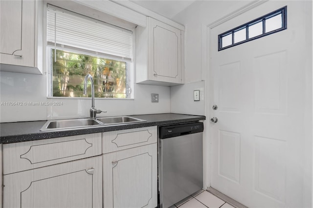 kitchen with dishwasher, light tile patterned floors, and sink