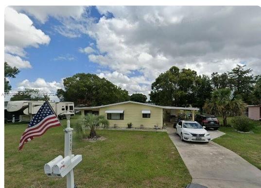 view of front facade featuring a carport and a front lawn