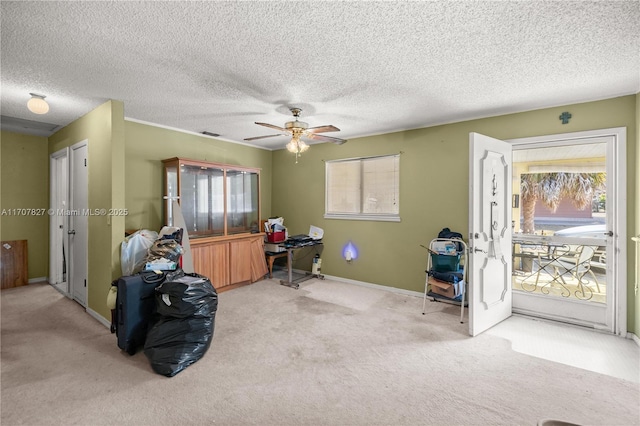 misc room with ceiling fan, a healthy amount of sunlight, light colored carpet, and a textured ceiling