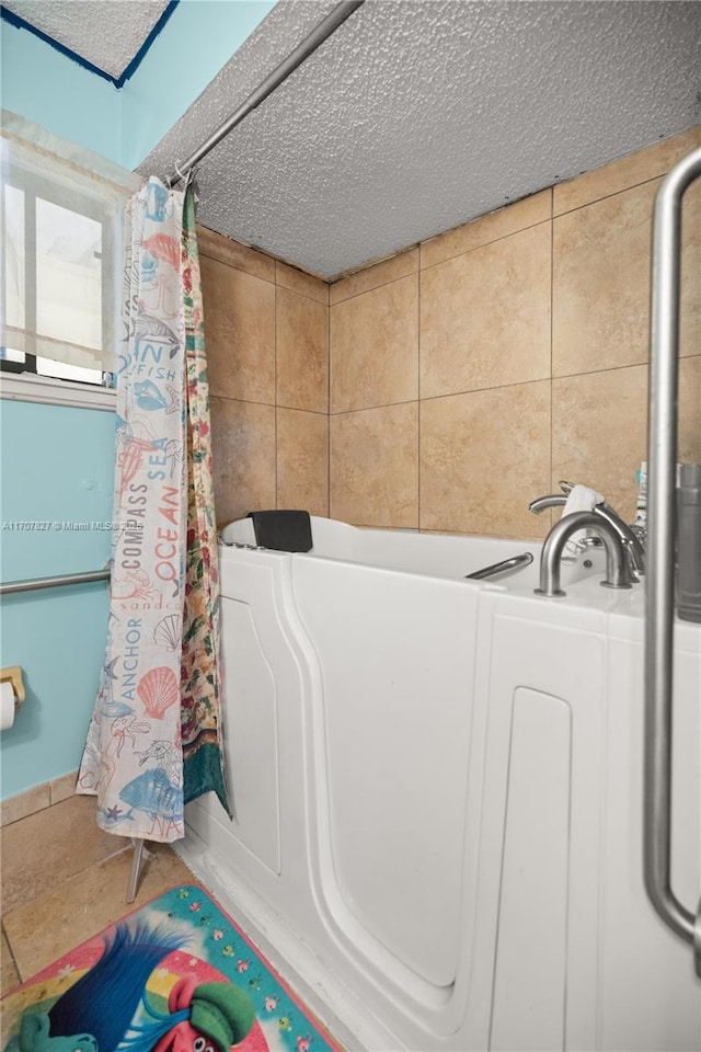 bathroom featuring a washtub and a textured ceiling