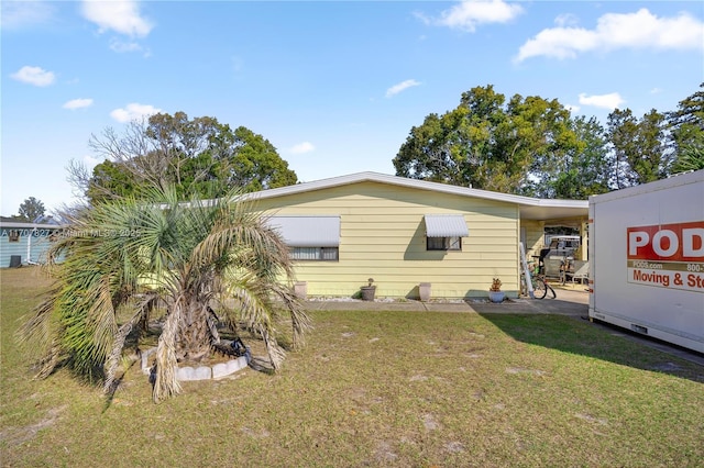 exterior space with a carport and a lawn