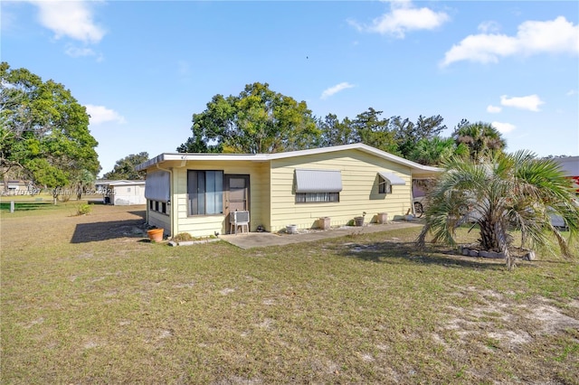 rear view of property featuring a lawn