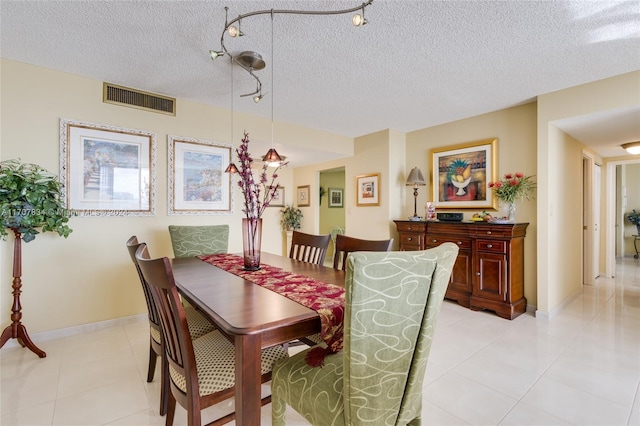 tiled dining space featuring a textured ceiling