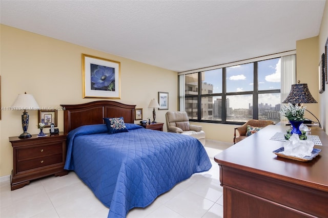 bedroom with light tile patterned floors and a textured ceiling