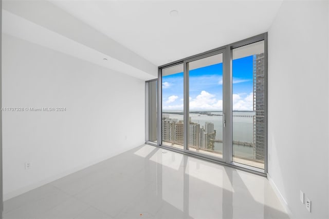 spare room featuring a water view and floor to ceiling windows