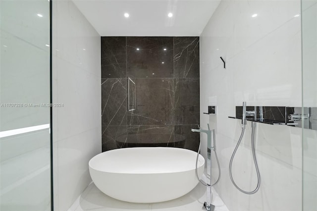 bathroom featuring a bathtub and tile walls