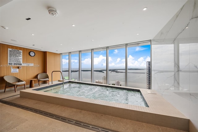 view of swimming pool with a water view and an indoor in ground hot tub