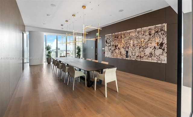 unfurnished dining area with light wood-type flooring and an inviting chandelier