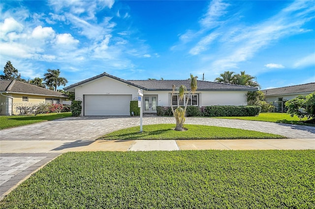 ranch-style home featuring a front yard, french doors, and a garage