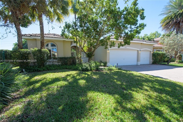 mediterranean / spanish house with a garage and a front lawn