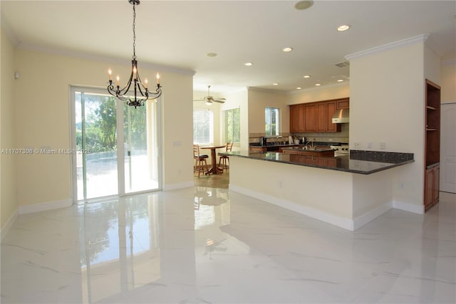 kitchen featuring decorative light fixtures, ventilation hood, dark stone countertops, ornamental molding, and kitchen peninsula