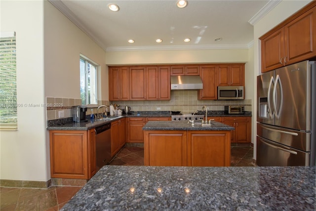 kitchen featuring sink, decorative backsplash, a center island with sink, and appliances with stainless steel finishes