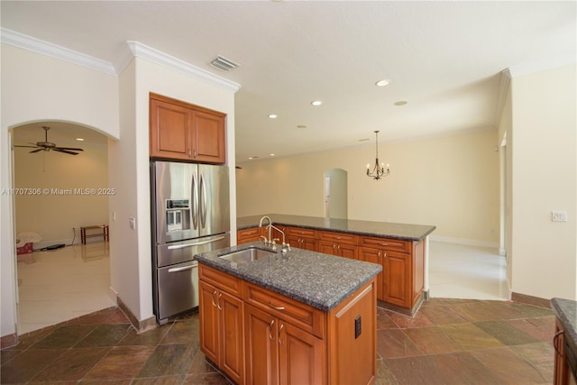 kitchen featuring pendant lighting, sink, crown molding, a kitchen island with sink, and stainless steel fridge with ice dispenser