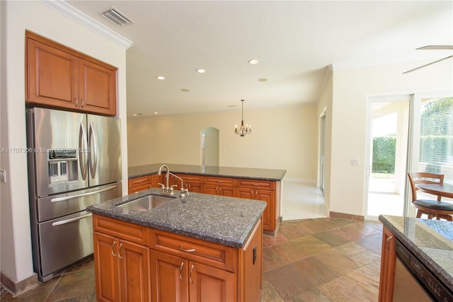 kitchen with pendant lighting, sink, crown molding, appliances with stainless steel finishes, and a kitchen island with sink