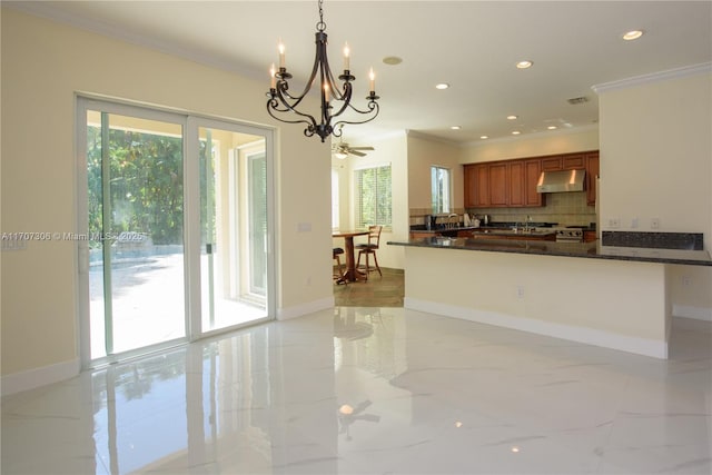 kitchen featuring dark stone countertops, decorative light fixtures, plenty of natural light, and kitchen peninsula