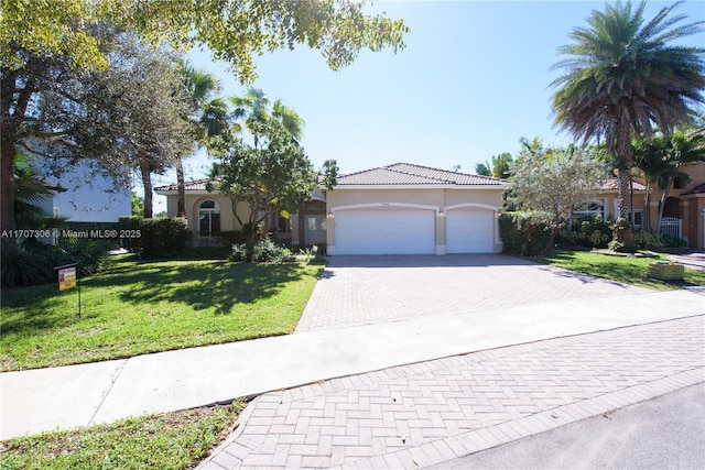 mediterranean / spanish home featuring a garage and a front yard