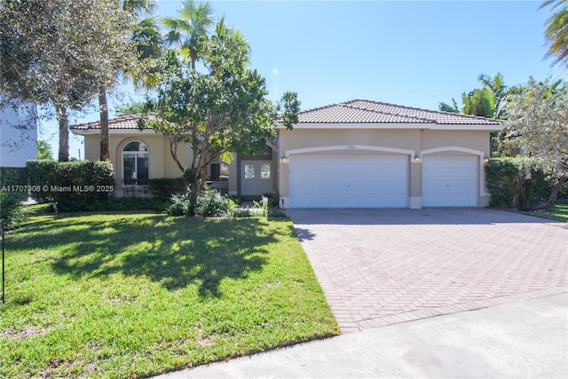 mediterranean / spanish-style home featuring a garage and a front yard