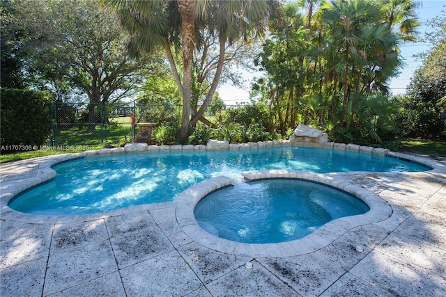 view of swimming pool with an in ground hot tub