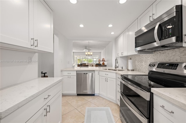 kitchen featuring white cabinetry, sink, a notable chandelier, backsplash, and appliances with stainless steel finishes