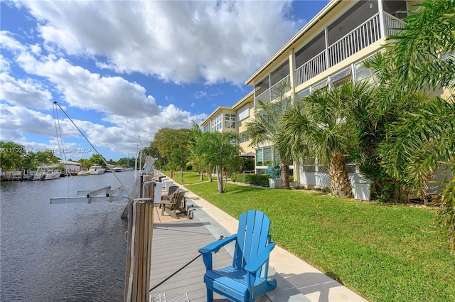 dock area featuring a lawn and a water view