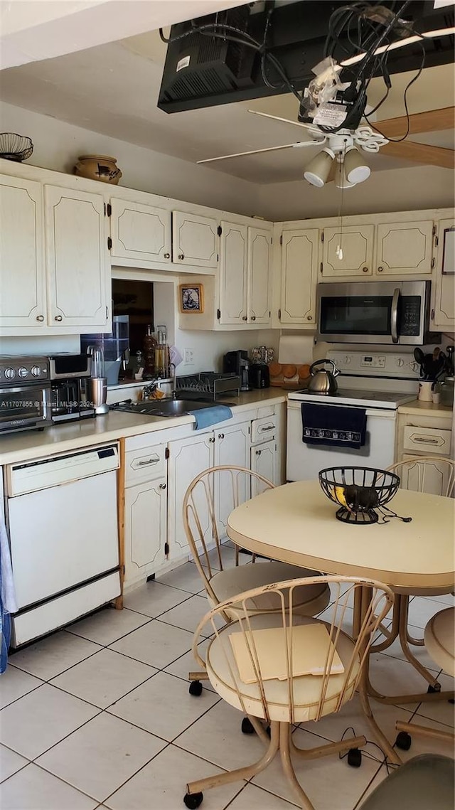 kitchen featuring ceiling fan, sink, light tile patterned floors, and white appliances