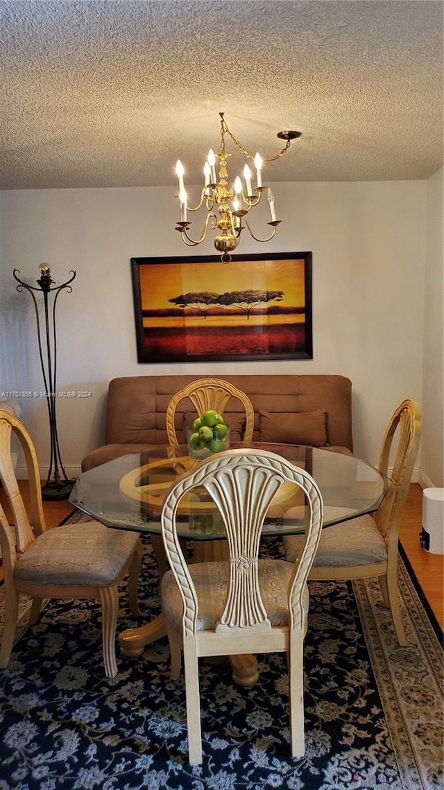 dining room with a chandelier and a textured ceiling