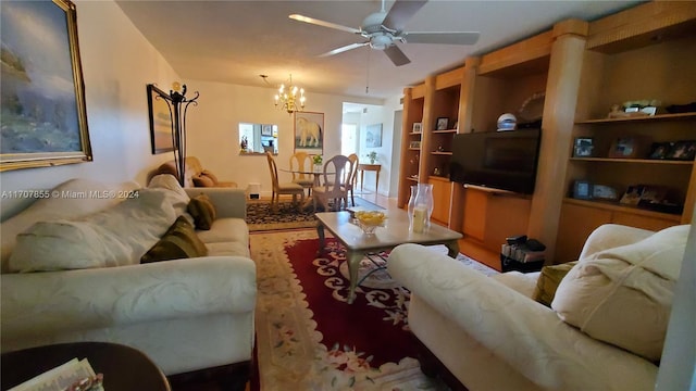 living room with ceiling fan with notable chandelier and hardwood / wood-style flooring