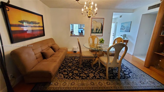 dining room with wood-type flooring and an inviting chandelier