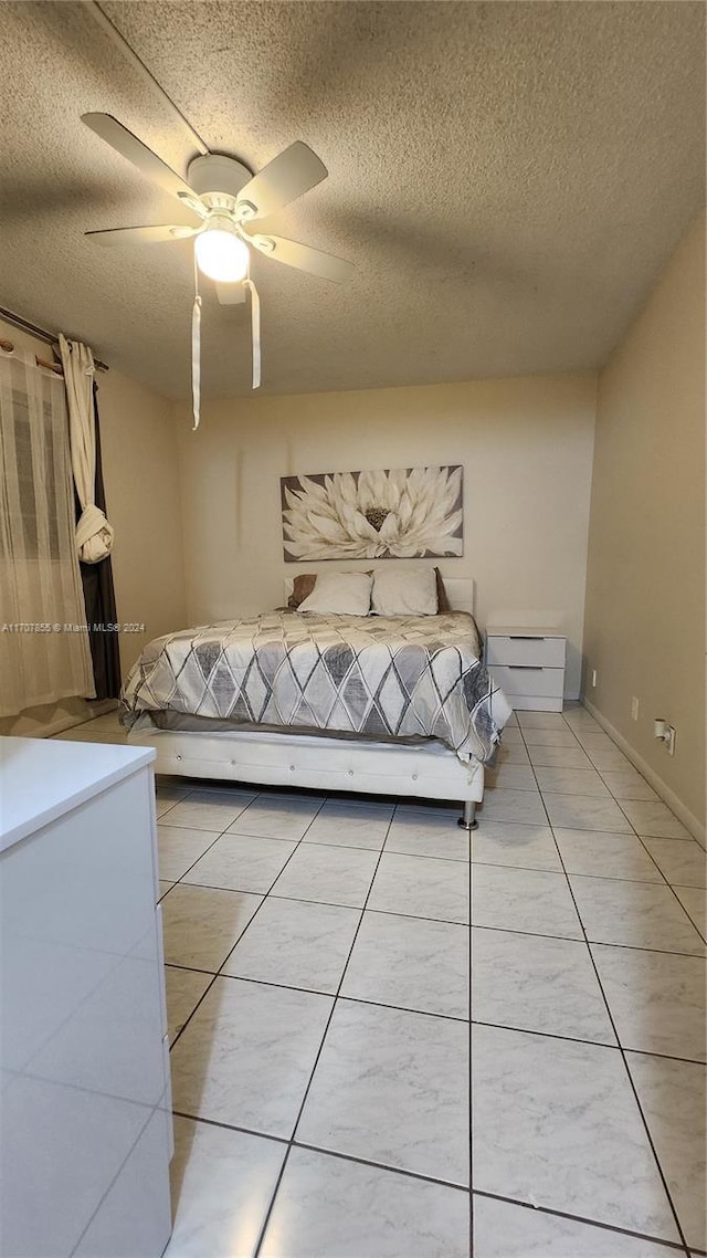 unfurnished bedroom with tile patterned flooring, ceiling fan, and a textured ceiling