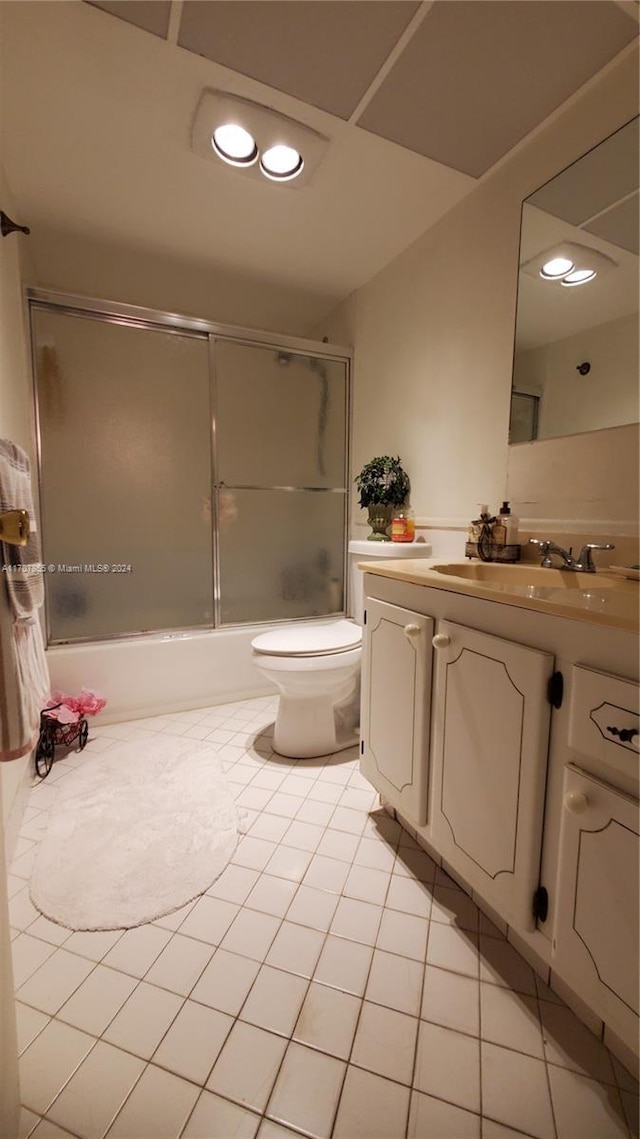 full bathroom with tile patterned flooring, vanity, toilet, and enclosed tub / shower combo