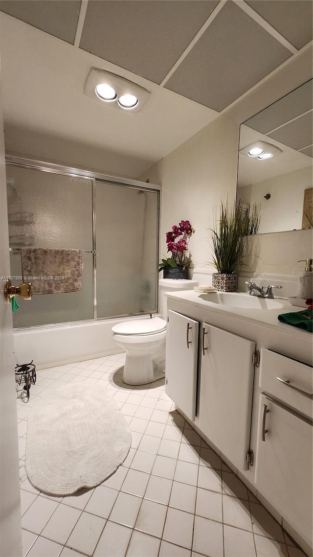 full bathroom with tile patterned flooring, vanity, toilet, and combined bath / shower with glass door