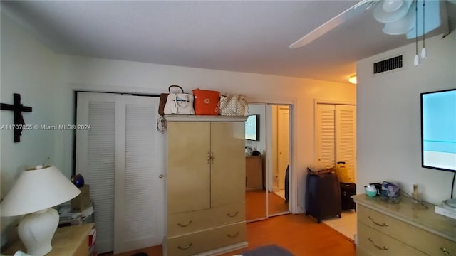 bedroom featuring ceiling fan and multiple closets