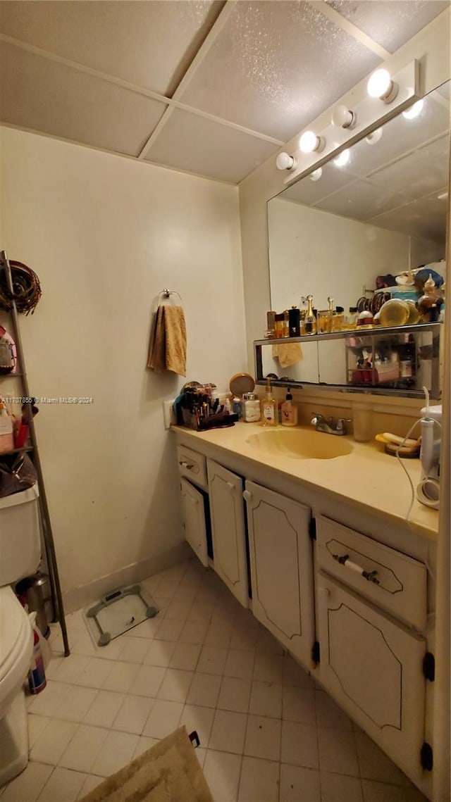 bathroom featuring tile patterned flooring, vanity, and toilet