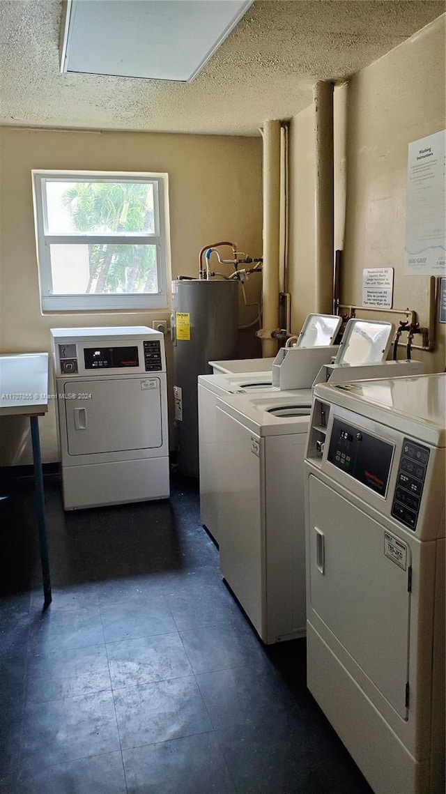 washroom with washer and clothes dryer, a textured ceiling, and water heater