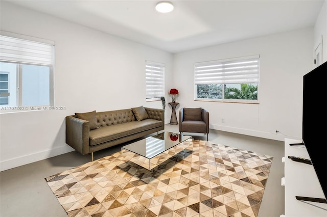 living room featuring concrete floors and a healthy amount of sunlight