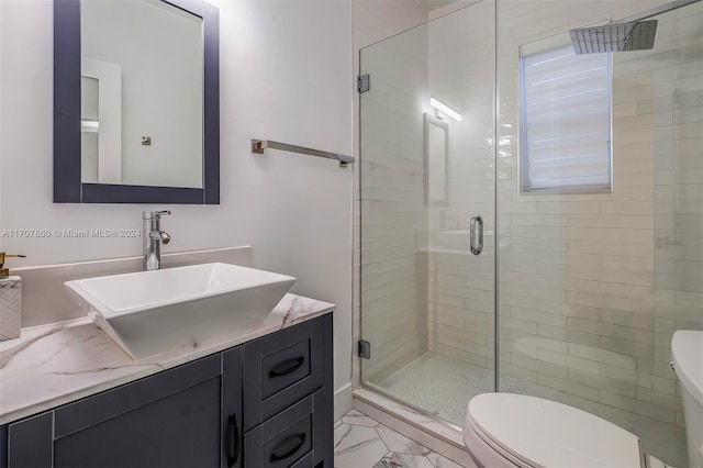 bathroom with a shower with door, vanity, and toilet