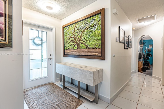 tiled foyer entrance with a textured ceiling