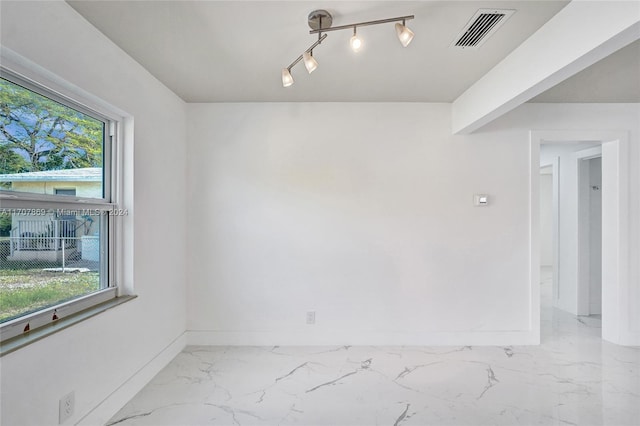 spare room featuring rail lighting