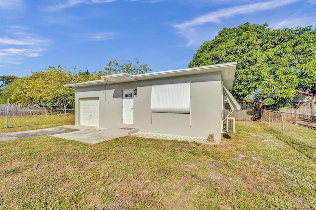 back of house featuring a garage and a yard