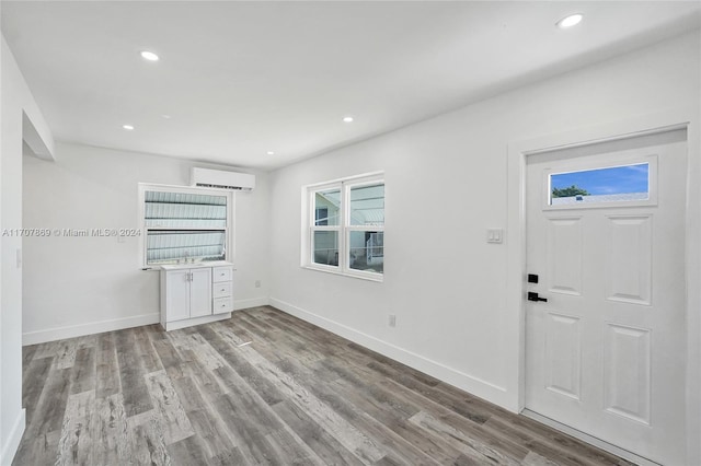 entryway with a wall mounted air conditioner and light hardwood / wood-style flooring