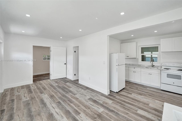 kitchen with white cabinets, white appliances, light hardwood / wood-style flooring, and sink