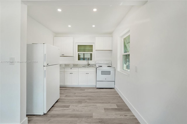 kitchen with sink, white cabinets, light hardwood / wood-style floors, and white appliances