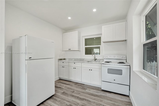 kitchen with white cabinets, white appliances, light hardwood / wood-style flooring, and sink