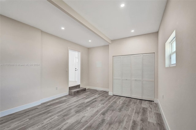 unfurnished bedroom with a closet and light hardwood / wood-style flooring