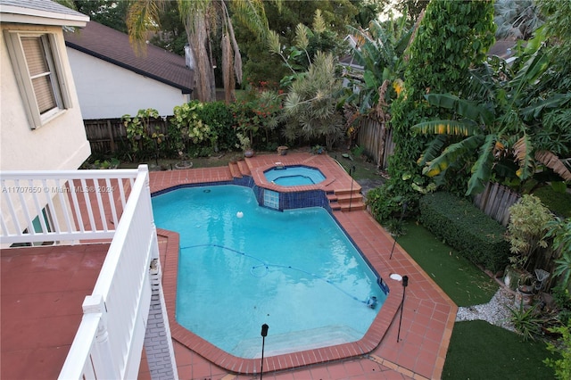 view of swimming pool with an in ground hot tub