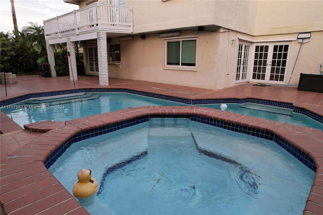 view of swimming pool featuring an in ground hot tub, a patio, and french doors