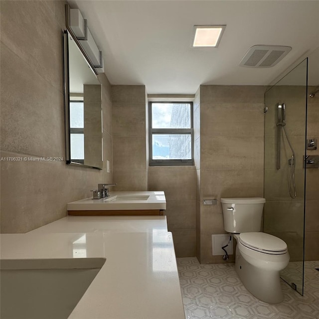 bathroom featuring walk in shower, vanity, toilet, and tile walls